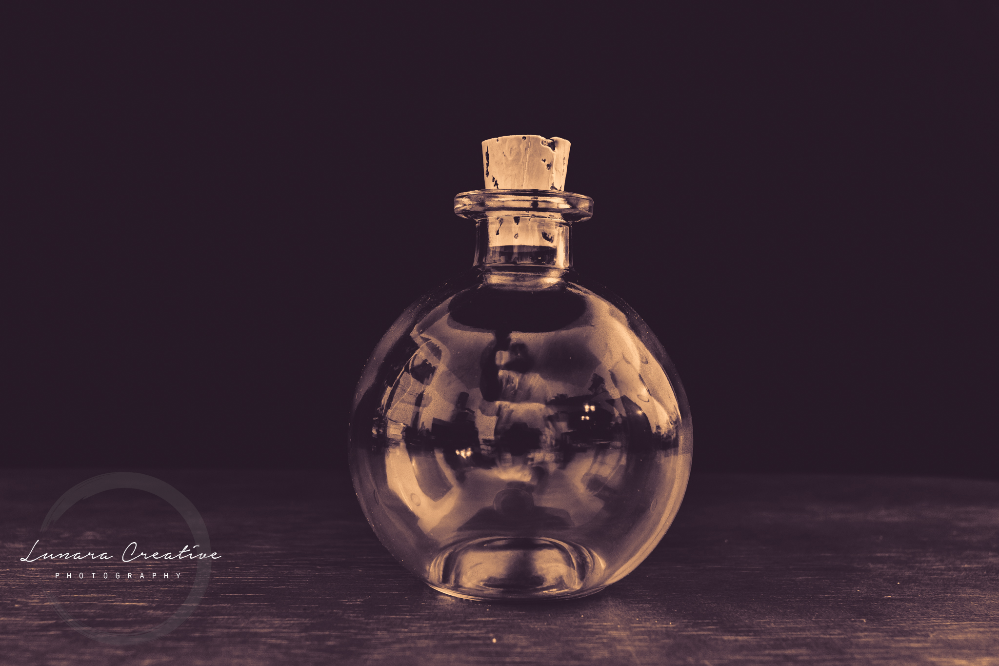 Tiny Bottle - A tiny bottle sitting on a table.  Photo was tinted with a hint of purple color. by Lunara Creative Photography